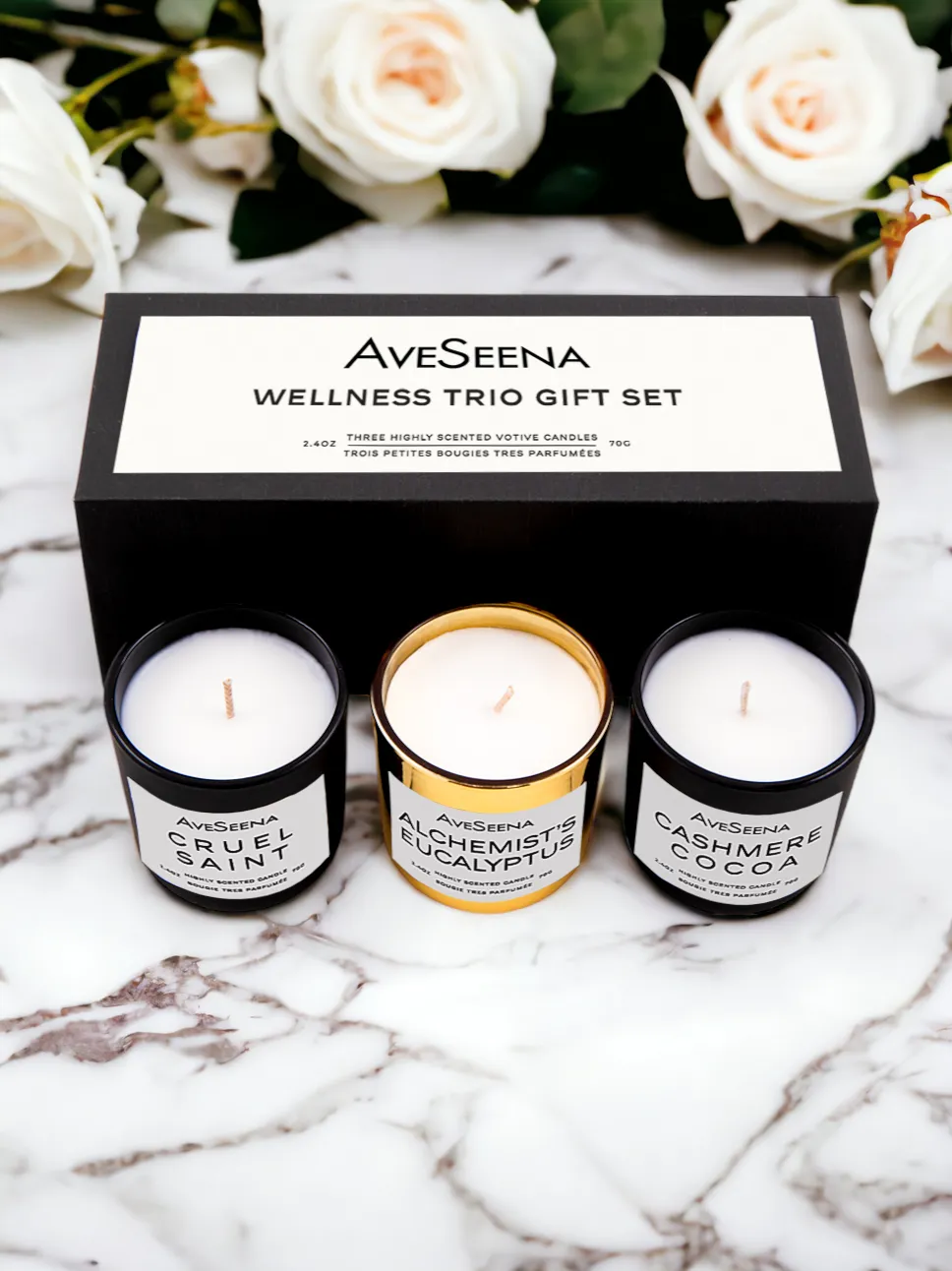 AveSeena Wellness Trio Gift Candle Set featuring three highly scented votive candles: Cruel Saint, Alchemist Eucalyptus, and Cashmere Cocoa, elegantly displayed in a black box on a marble surface.