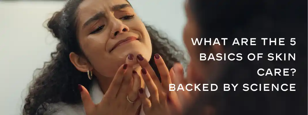 woman looking at her skin with acne and hyperpigmentation