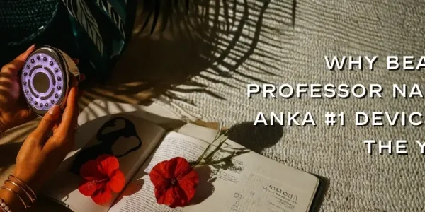 Hands holding a glowing beauty device above an open book with two red flowers. Text reads, "Why Beauty Professor Named Anka #1 Device of the Year."