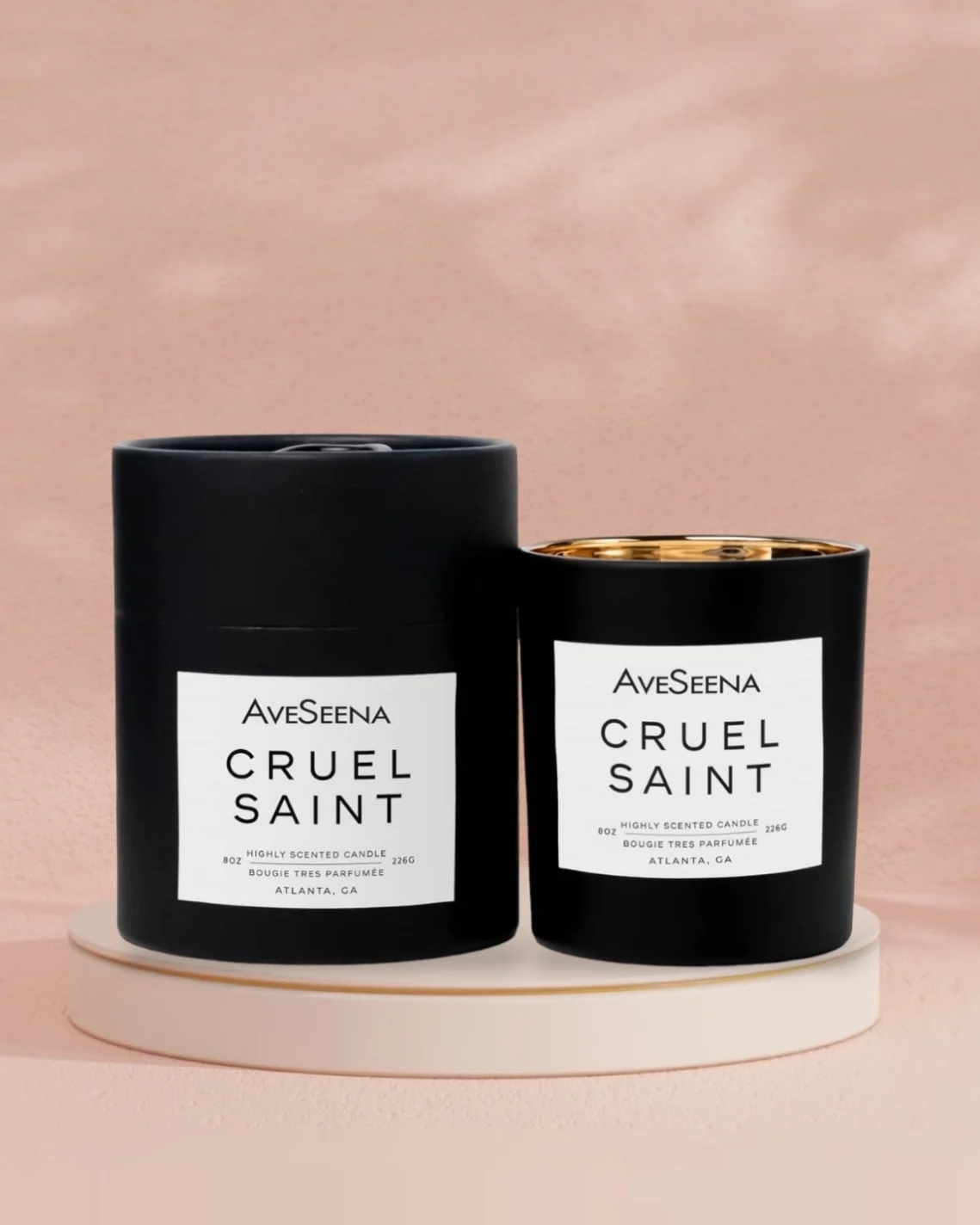 cruel saint candle and box on a pink table